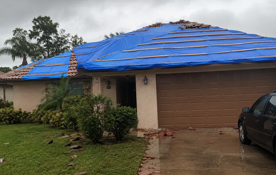 Emergency roof repair in Pompano Beach FL, storm tarp on a damaged roof